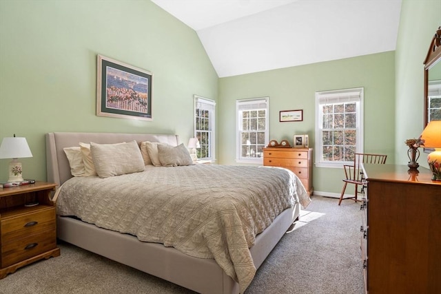 bedroom featuring baseboards, lofted ceiling, and light carpet