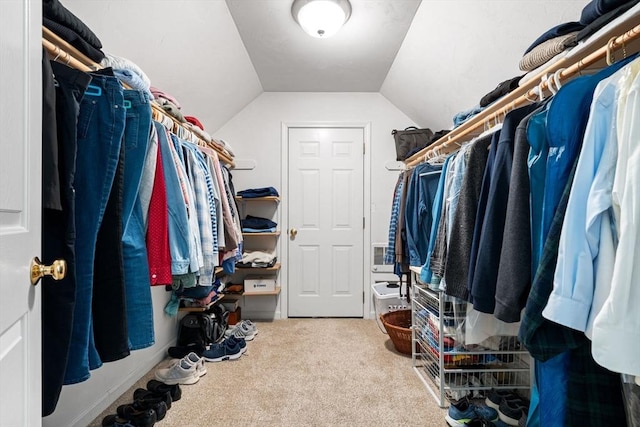 walk in closet featuring lofted ceiling and carpet floors