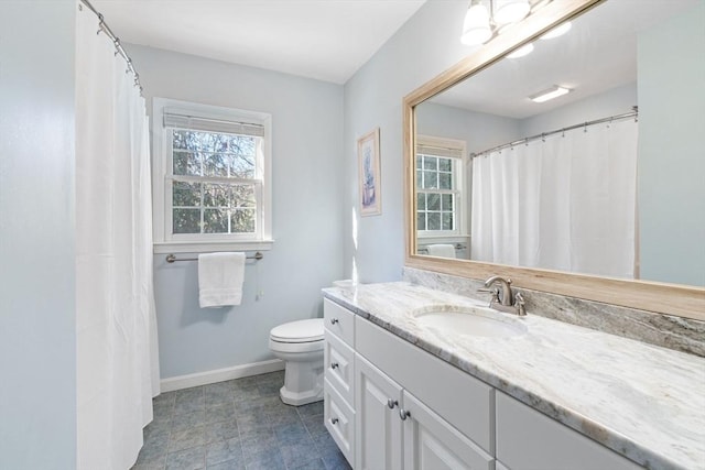 bathroom featuring baseboards, toilet, and vanity