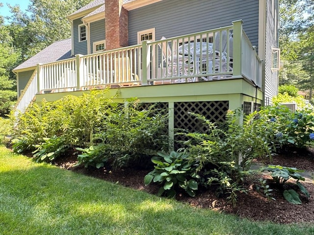 back of property with a chimney and a deck