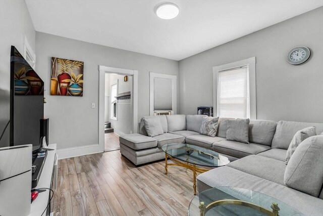 living area featuring baseboards and light wood-style floors