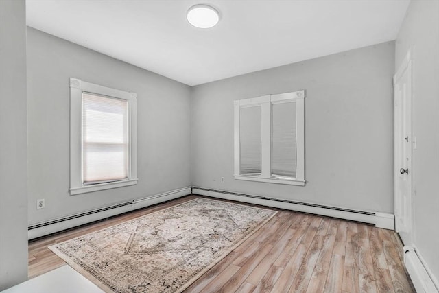 empty room featuring a baseboard radiator and wood finished floors