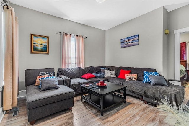 living area featuring visible vents and wood finished floors
