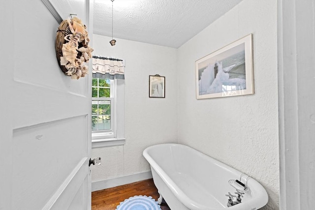 590 Hatherly Rd, Scituate, MA 02066 - bathroom with a freestanding bath, wood finished floors, and a textured ceiling