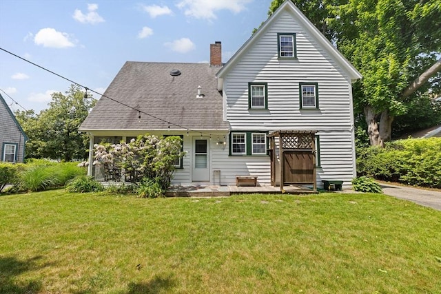 590 Hatherly Rd, Scituate, MA 02066 - back of property featuring a chimney, a lawn, a patio area, and a shingled roof
