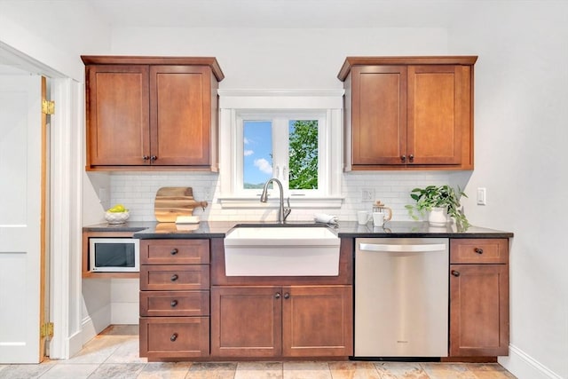 kitchen featuring dishwasher, a sink, white microwave, decorative backsplash, and baseboards