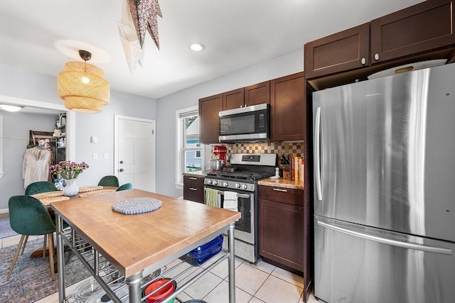 115 Elm St, Somerville, MA 02144 - kitchen featuring stainless steel appliances, dark brown cabinetry, decorative backsplash, light countertops, and light tile patterned floors