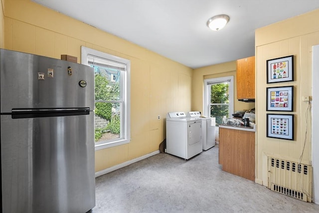 115 Elm St, Somerville, MA 02144 - laundry area featuring radiator, washing machine and clothes dryer, and plenty of natural light