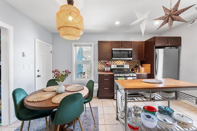115 Elm St, Somerville, MA 02144 - kitchen featuring stainless steel appliances, tasteful backsplash, light tile patterned flooring, hanging light fixtures, and recessed lighting