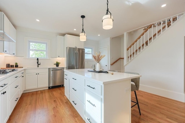 179 Main Unit 2, Medford, MA 02155 - kitchen featuring stainless steel appliances, a sink, a kitchen bar, a center island, and light wood finished floors