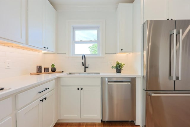 179 Main Unit 2, Medford, MA 02155 - kitchen with stainless steel appliances, a sink, decorative backsplash, white cabinets, and light countertops