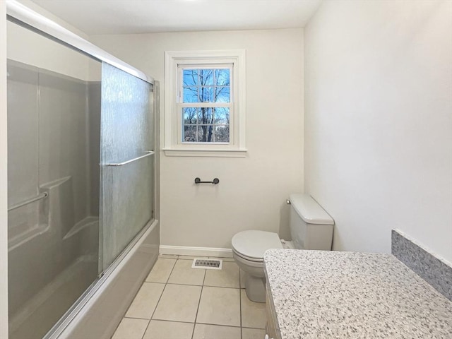 full bath with baseboards, visible vents, shower / bath combination with glass door, tile patterned flooring, and toilet