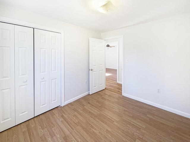 unfurnished bedroom featuring a closet, baseboards, and light wood-style floors