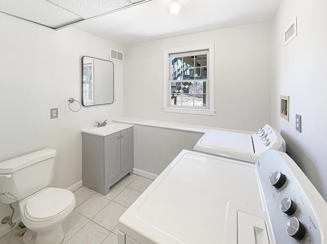 bathroom featuring independent washer and dryer, toilet, visible vents, and tile patterned flooring