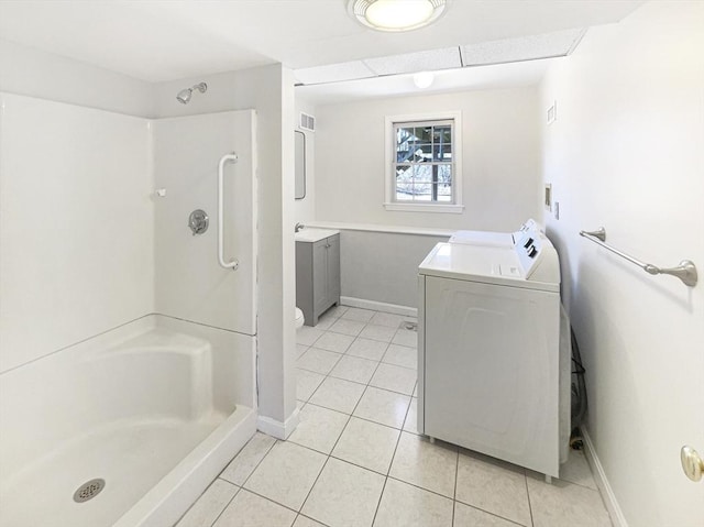 bathroom with tile patterned floors, washing machine and dryer, a stall shower, and vanity