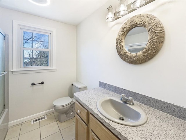 bathroom with vanity, baseboards, visible vents, tile patterned floors, and toilet