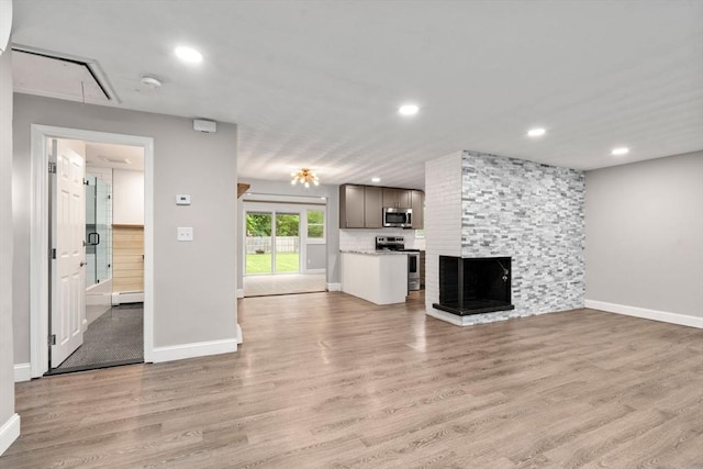 13 Campello Rd, Framingham, MA 01701 - unfurnished living room with attic access, baseboards, light wood-style flooring, recessed lighting, and a multi sided fireplace