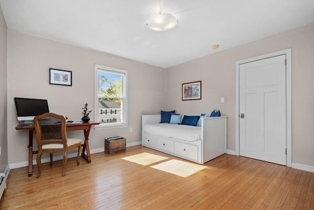 office with light wood finished floors, baseboards, and a baseboard heating unit