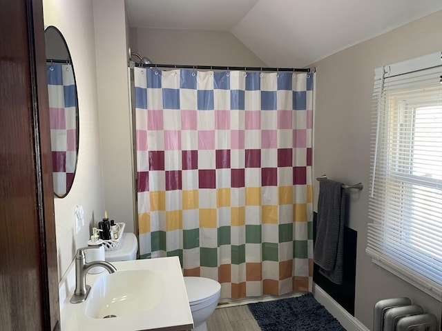 bathroom featuring radiator, toilet, vaulted ceiling, a shower with curtain, and vanity