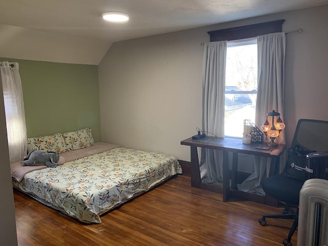 bedroom featuring wood finished floors and lofted ceiling