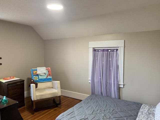bedroom with wood finished floors, baseboards, and vaulted ceiling