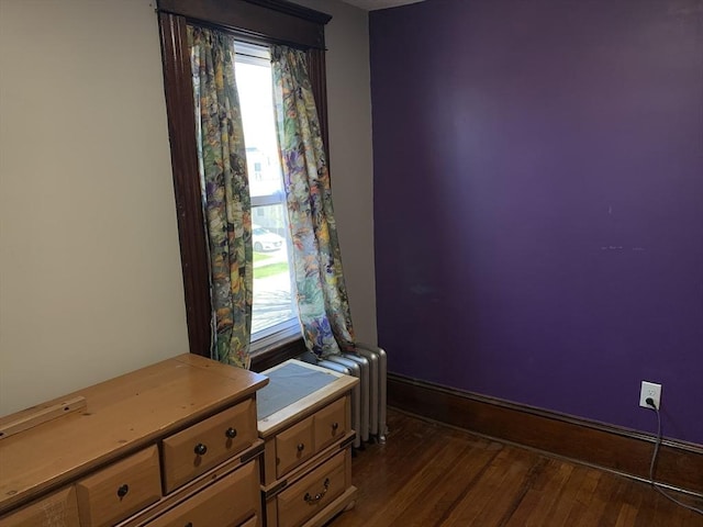 unfurnished room featuring radiator and dark wood finished floors