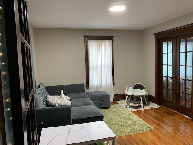 living room with french doors, wood finished floors, and baseboards