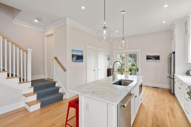 68 Summer St Unit B, Natick, MA 01760 - kitchen featuring a sink, light wood-type flooring, appliances with stainless steel finishes, a center island with sink, and white cabinets