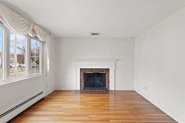 unfurnished living room featuring a baseboard radiator, visible vents, light wood-style flooring, a brick fireplace, and baseboards