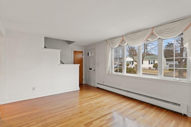 spare room with a baseboard radiator and wood finished floors