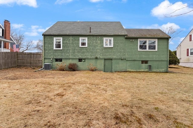 rear view of house with central air condition unit and fence