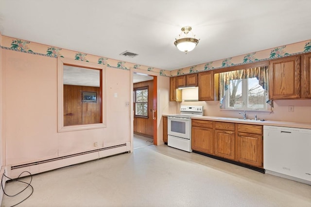 kitchen with white appliances, a sink, light countertops, baseboard heating, and brown cabinetry