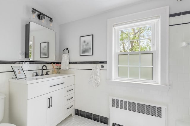 118 Academy Ave, Weymouth, MA 02188 - bathroom featuring radiator, tile walls, vanity, toilet, and tile patterned flooring