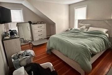 bedroom with dark hardwood / wood-style flooring and multiple windows