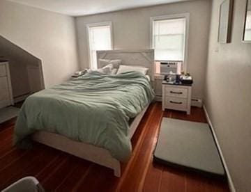 bedroom featuring multiple windows, cooling unit, and dark wood-type flooring