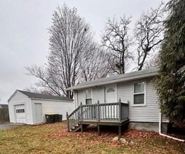 view of front of house with a garage, an outdoor structure, and a wooden deck