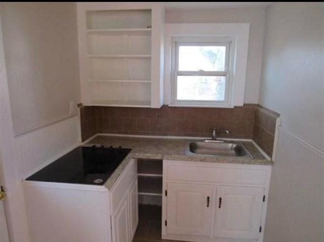 kitchen featuring white cabinetry and sink