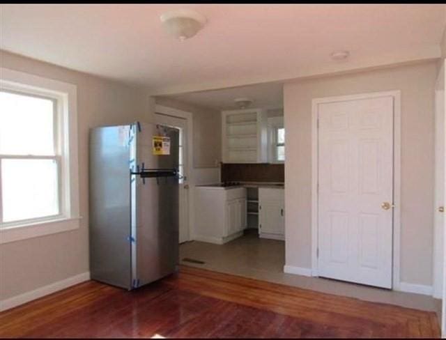 kitchen featuring white cabinetry, stainless steel fridge, and hardwood / wood-style floors