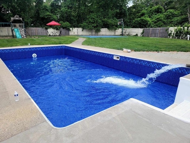 view of swimming pool featuring a fenced backyard, a fenced in pool, a playground, and a yard