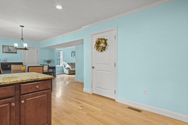 41 Belmont Ave Unit 41, Haverhill, MA 01830 - kitchen featuring ornamental molding, light wood-type flooring, baseboards, hanging light fixtures, and light stone counters
