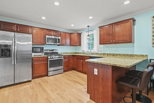 41 Belmont Ave Unit 41, Haverhill, MA 01830 - kitchen featuring appliances with stainless steel finishes, a peninsula, crown molding, light wood-type flooring, and pendant lighting