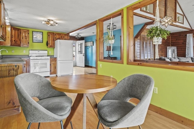 dining area featuring light wood finished floors and baseboards