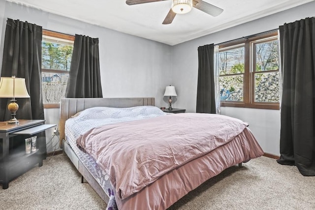 carpeted bedroom featuring ceiling fan and baseboards