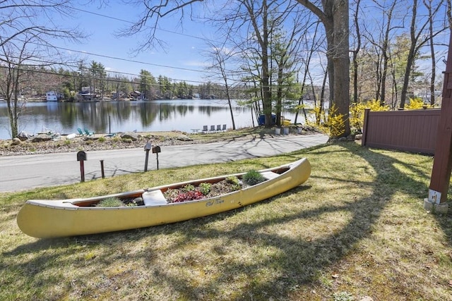 view of yard featuring fence and a water view