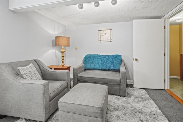 sitting room featuring carpet flooring and baseboards
