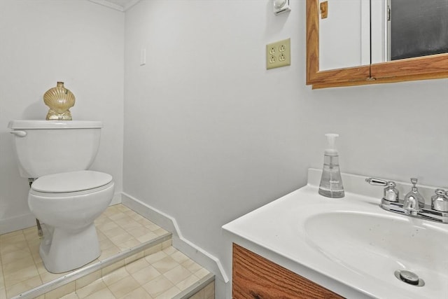 bathroom featuring toilet, tile patterned floors, vanity, and baseboards