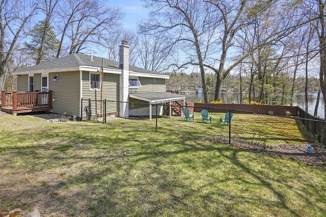 exterior space with a fenced backyard and a deck with water view