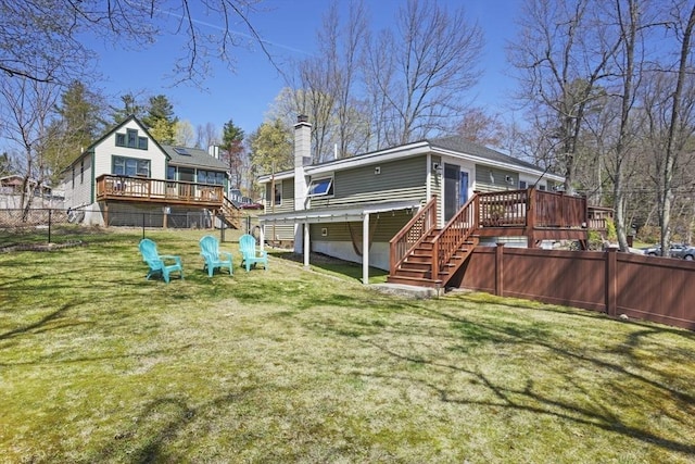 back of property featuring a deck, fence, a chimney, and stairs