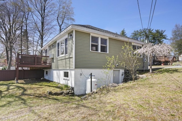 view of property exterior with a wooden deck and a lawn