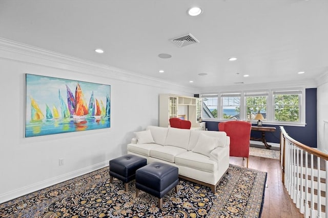 living room featuring wood-type flooring and crown molding